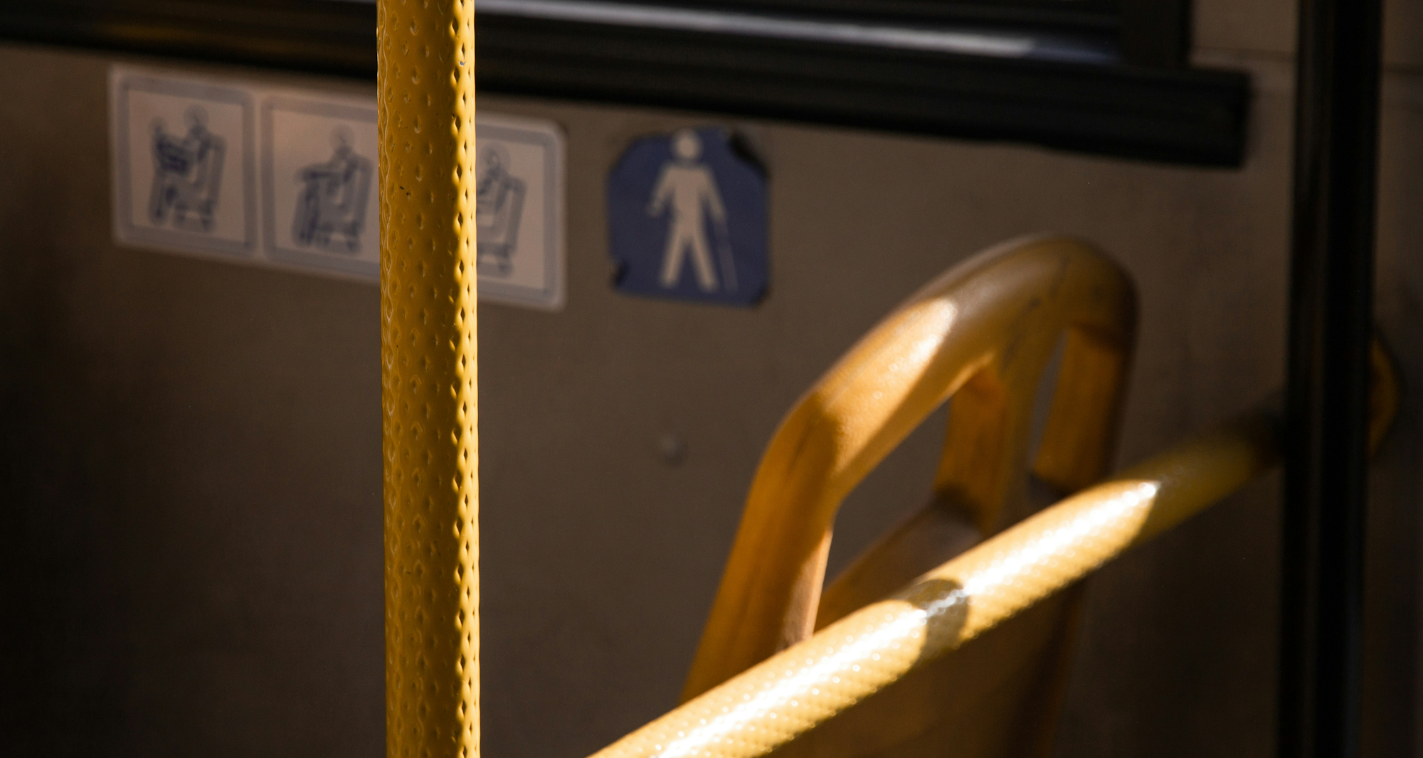 Interior of a bus featuring a designated seat designed for elderly passengers and individuals with disabilities