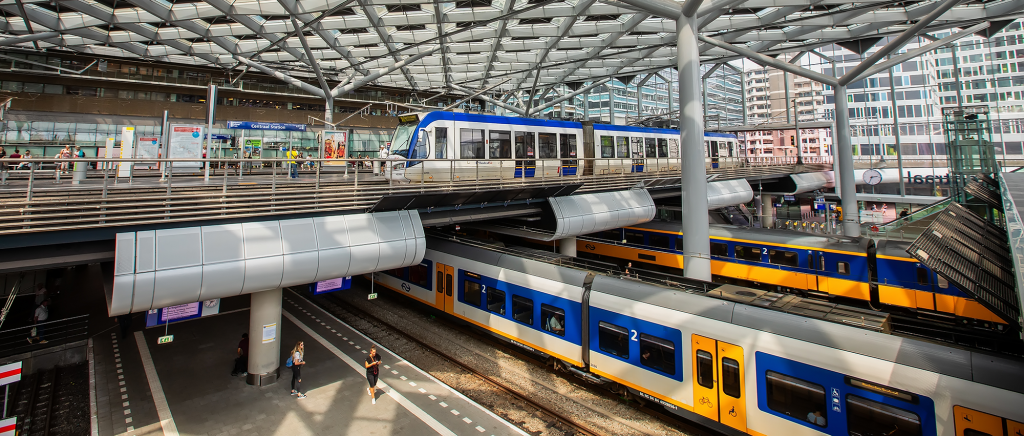 Interior view of The Hague Central Station, showing trains on the lower level and trams on the elevated platforms